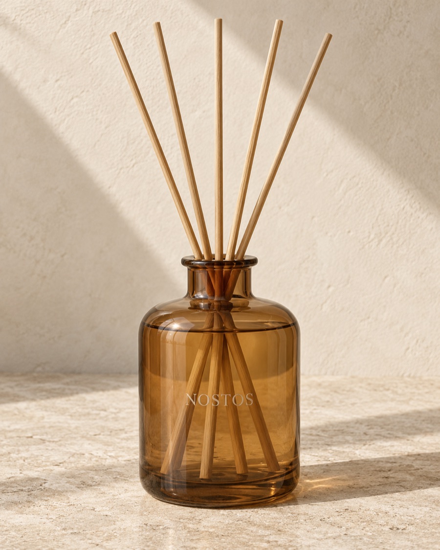 NOSTOS concept room diffuser in amber, photographed on warm limestone.